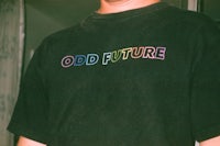 a man wearing a black t - shirt with the word odd future on it