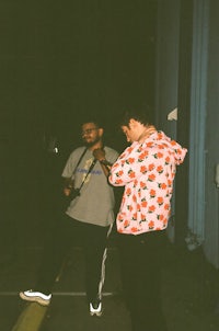 two men standing next to each other at night