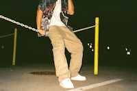 a man on a cell phone standing on a chain